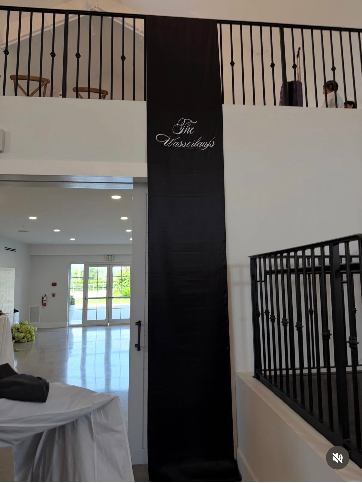 Personalized black fabric wedding sign hanging vertically inside a venue
